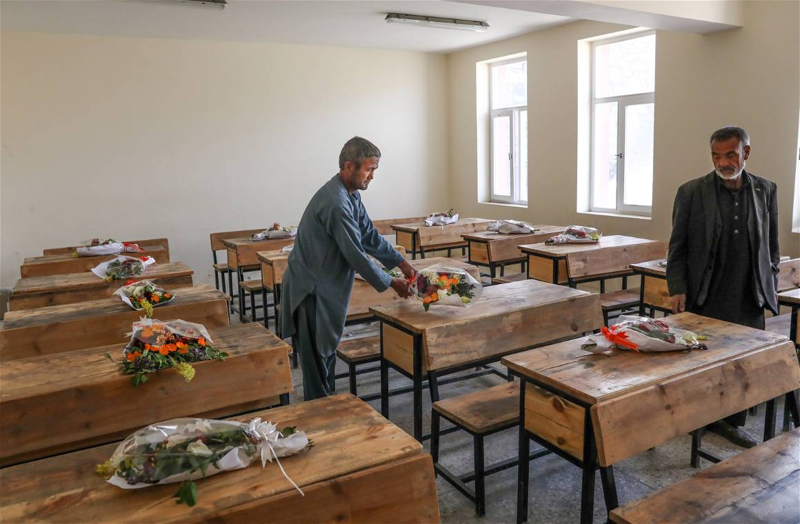 Afghan School workers puts donated bouquets of flowers from the Kabul municipality on the empty desks of killed students as a tribute to their loss in Sayyid al-Shuhada school in the west Kabul. HEDAYATULLAH AMID