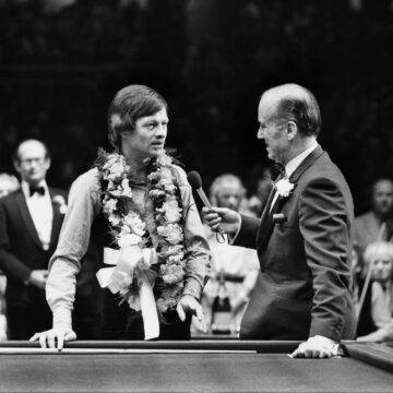 IMAGO / Colorsport | Alex Higgins (Northern Ireland) talks with TV Presenter Peter West. Benson & Hedges Championship snooker 1981.