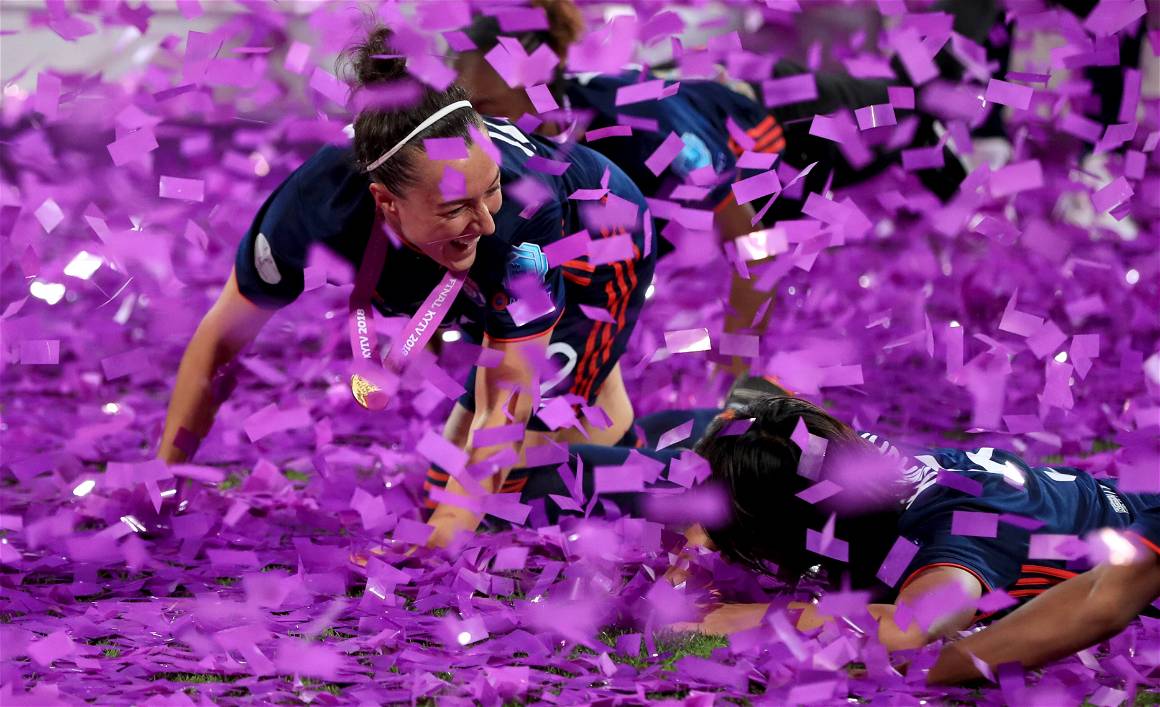 Lucy Bronze and her teammate celebrate in purple confetti.