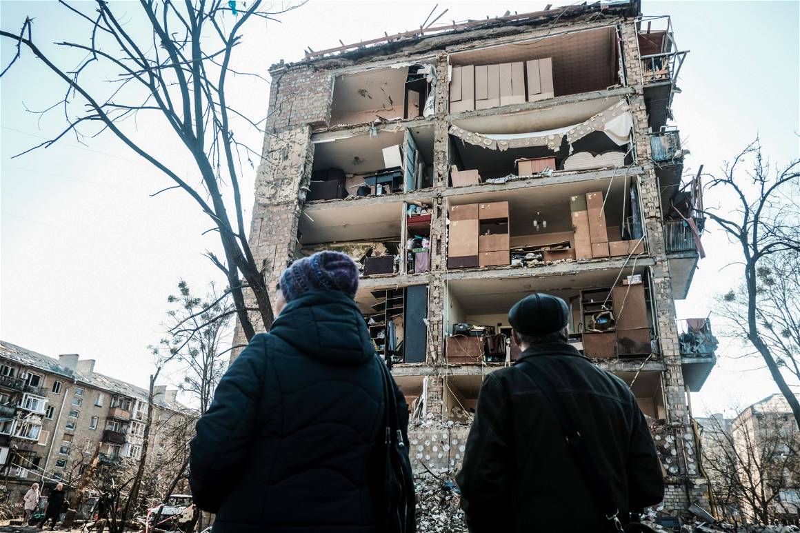 IMAGO / ZUMA Wire / Matthew Hatcher. March 19, 2022, Kyiv, Ukraine: Residents look at a destroyed apartment building following a Russian air strike in the residential neighborhood of Podil in Kyiv, Ukraine.