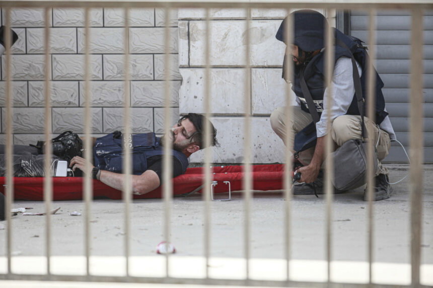 Journalists carry an injured colleague in the Jenin refugee camp.